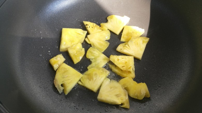 菠萝咕咾肉,锅中放油，放入菠萝煎至表面金黄