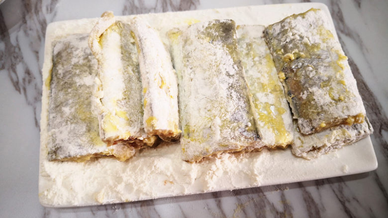 香煎带鱼,裹好面粉的带鱼放在一边静置一会儿,再把多余的面粉抖掉,