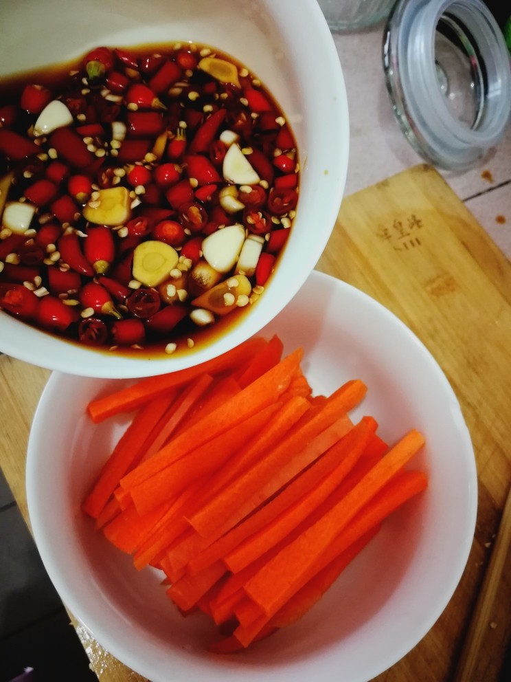 泡椒凤爪,在煮凤爪的过程，把先前拌好料倒入装有胡萝卜的碗里。