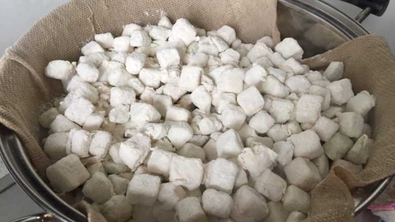 茄子麦饭,倒入剩余的1/3面粉,用手拌匀,让茄子表面很干爽,保持一粒粒的状态,铺上蒸布,把茄子铺匀