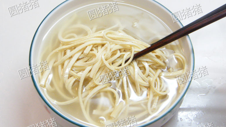凉拌干丝——让干丝柔软的窍门,在碗内注入一碗烧开的热开水,用筷子略搅拌一下,放置浸泡2分钟。