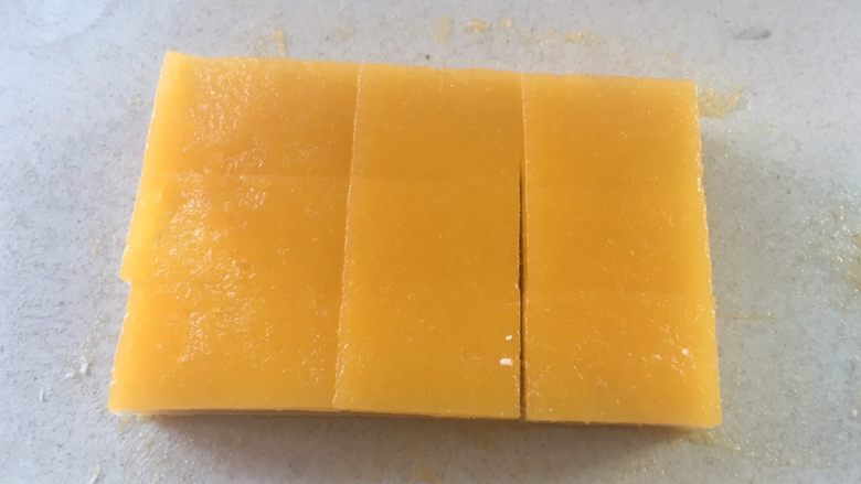 芒果千层糕,冷藏3个小时后,用刮刀轻刮一下四周,之后倒扣取出模具,裁掉四周切成小块即可