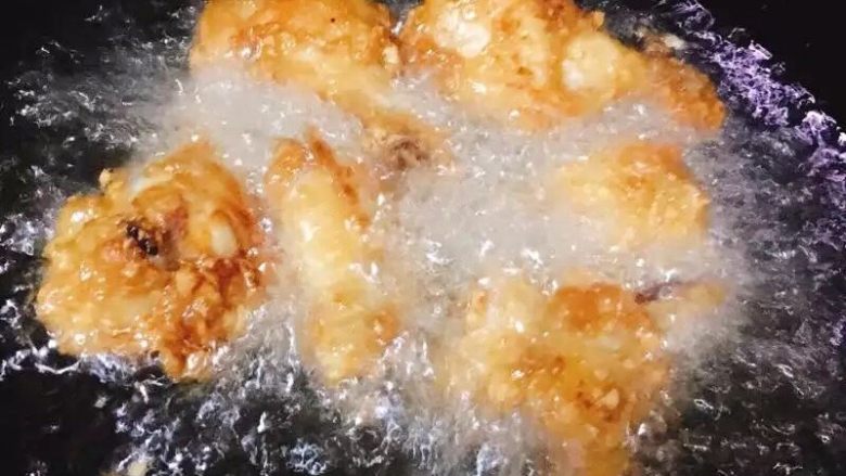 蒜香炸鸡翅  独家吮指美味,一面好了再翻面炸，炸至两面金黄色，将鸡翅先捞出。