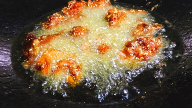 蒜香炸鸡翅  独家吮指美味,锅内油改中大火继续加热，加热至八九成热后，将鸡翅倒回锅中，大火快炸。约10秒即可捞起沥干。
