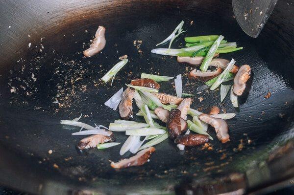 豆芽炒鸡肉,大火热锅加油,把蘑菇和葱头放进去炒。大伙炒20秒。转中火。