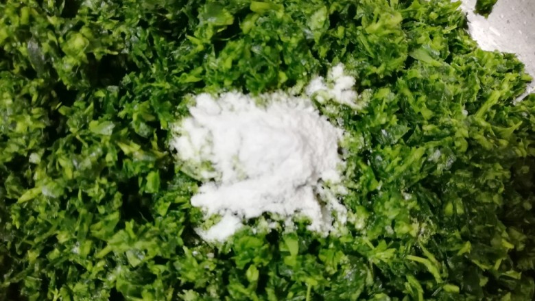 苜蓿菜菜团,剁好的苜蓿菜放在盆里,加入1g食用碱用手抓匀(放碱的目的是:为了让蒸好的苜蓿菜菜团不发黄,不喜欢的可以不加,不影响味道)。