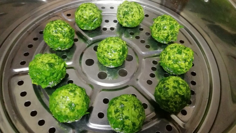 苜蓿菜菜团,蒸锅内放水烧开,篦子上抹油,放上做好的菜团,锅开以后转中火蒸30分钟(苜蓿菜不好熟,所以蒸时间长一点)。