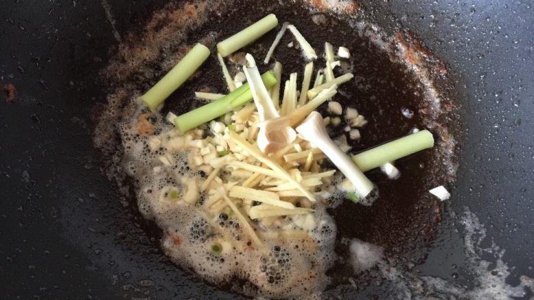 油焖大虾,倒出多余的油,保留锅内油脂,向锅中加入姜蒜爆香