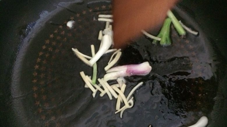 话梅焖剥皮鱼,热锅凉油,加入姜丝、葱白炒出香味。