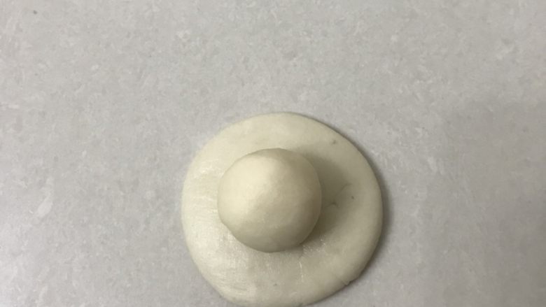 蛋黄酥,油皮面团用手掌压成圆形面皮放上油酥