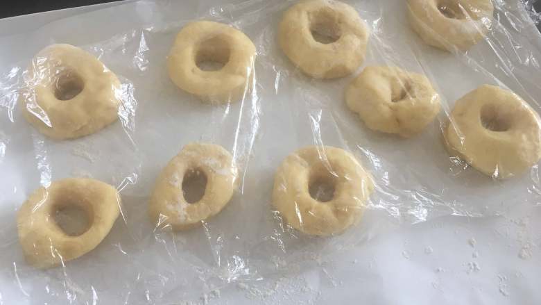 美味油炸版甜甜圈,整好形,放入撒好面粉的烤盘,盖上保鲜膜进行发酵;