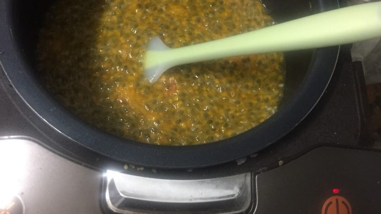 自制百香果果浆(电饭煲版),倒入电饭煲,煮开后开断搅拌。