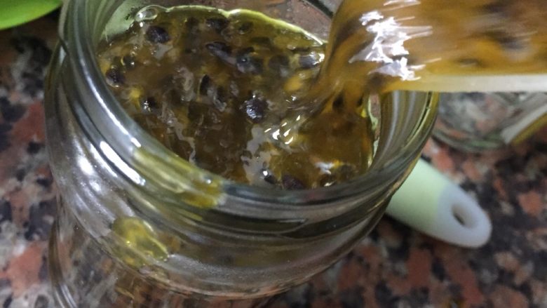 自制百香果果浆(电饭煲版),趁热倒入已经消毒好的玻璃瓶里,八分满,盖上盖子马上倒扣。