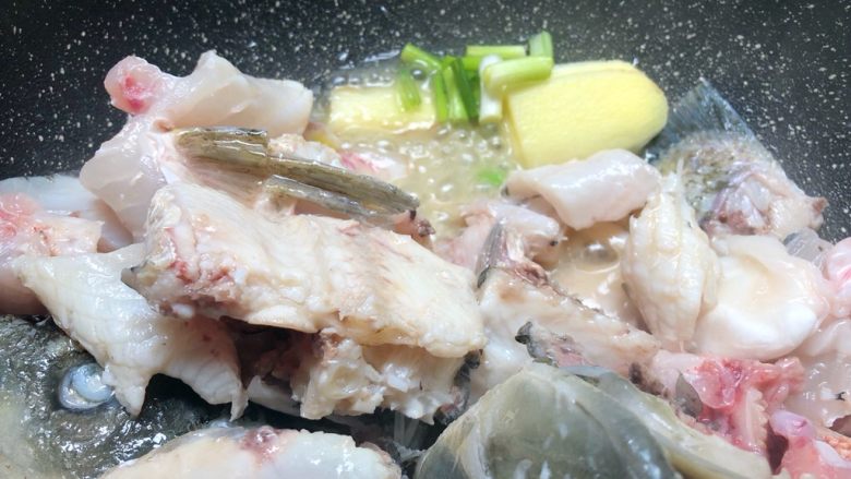 萝卜丝鱼骨汤,鱼骨煎好后拨到一边,放入葱白和姜片,煸出香味