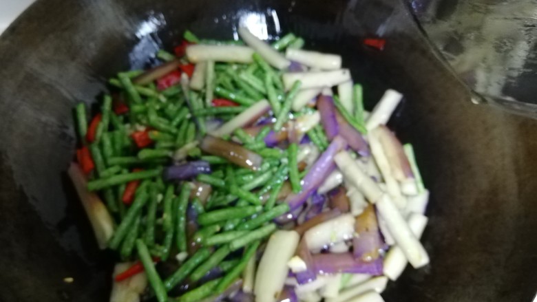 豆角茄条,蒜子辣椒爆香后,加入豆角茄条,翻炒。加入料酒,盐,酱油,翻炒一两分钟即可