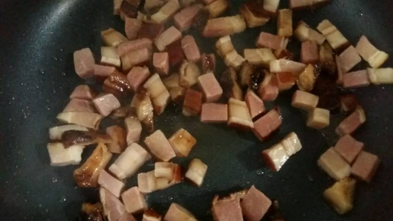 腊肉土豆焖饭,倒入腊肉小火翻炒2分钟,炒出腊肉的香味和油脂。