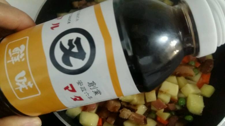 腊肉土豆焖饭,倒入一勺又伊鲜酱油。这里要特别说一下又伊鲜酱油,真的超级棒,打开盖子,超级浓的酱香味,好闻极了。
酱油汁浓度适中,倒入锅中颜色不是很重,特别合适,很鲜,菜翻炒起来也很香。