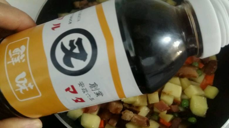 腊肉土豆焖饭,倒入一勺又伊鲜酱油。这里要特别说一下又伊鲜酱油，真的超级棒，打开盖子，超级浓的酱香味，好闻极了。

酱油汁浓度适中，倒入锅中颜色不是很重，特别合适，很鲜，菜翻炒起来也很香。