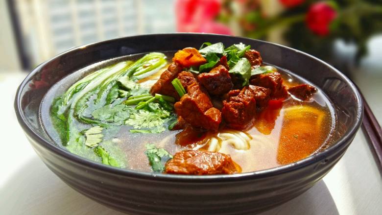 一碗幸福的红烧牛肉面,碗里盛入面条,加入煮面的汤,倒入1大勺牛肉连同汤汁。。放入2棵青菜。上面撒少许<a style='color:red;display:inline-block;' href='/shicai/ 131'>香菜</a>末。