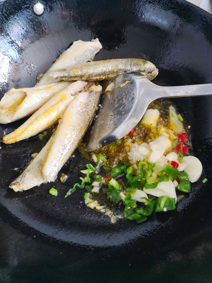 焖南极鱼,鱼推到一边。放入葱姜蒜,少许郫县豆瓣酱及半个小米椒,炒香。