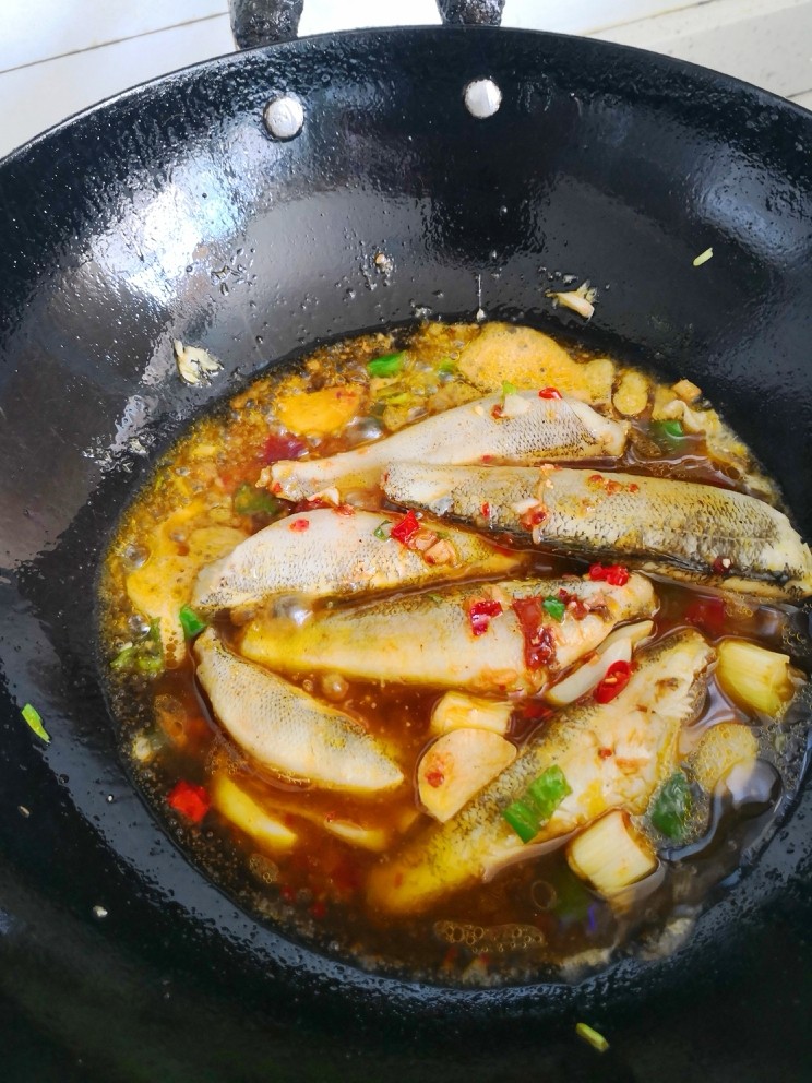 焖南极鱼,加入料酒。生抽。白糖,倒入高汤焖至汤汁粘稠。