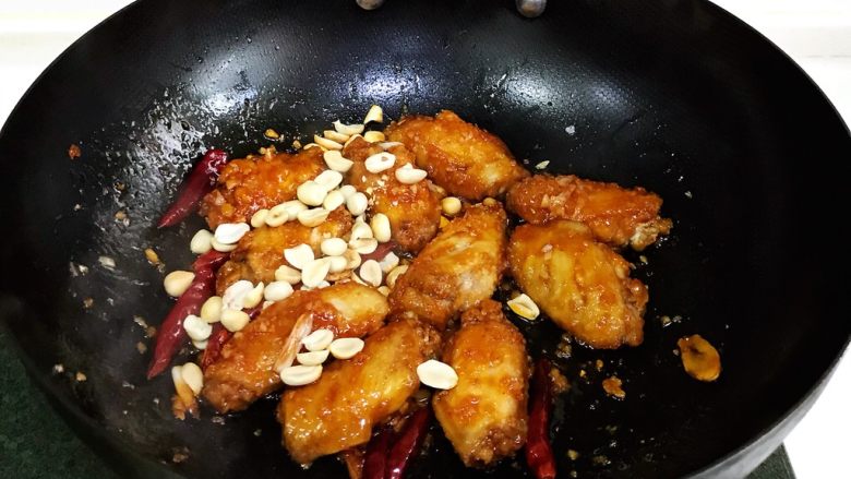 韩式吮指炸鸡翅,让鸡翅裹上慢慢的酱汁,最后撒入花生翻动下即可出锅。