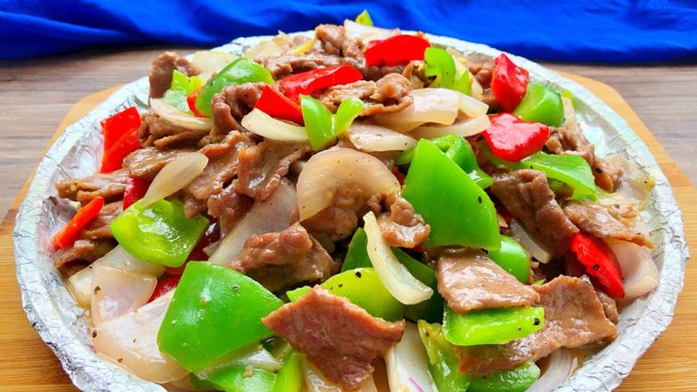 铁板牛肉,牛肉盛入铁板,可以放在煤气灶或者电磁炉再煮3分钟即可