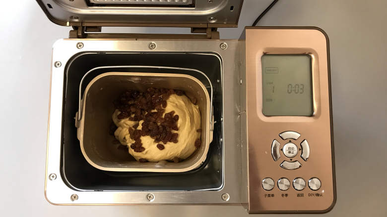 面包机版咕咕霍夫面包,并将准备好的酒渍葡萄干放入,继续和面至结束。