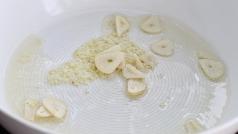 鲜虾小白菜豆腐汤,锅中倒少许油烧至五成热,放入姜末和蒜片小火炒出香味
