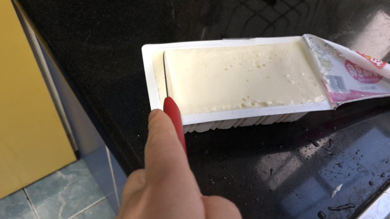 金针菇炖豆腐,内酯豆腐撕开封面,用小刀均匀地划成半厘米厚的片。