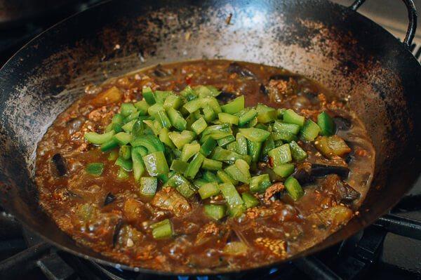 肉末茄子,加入1汤匙生抽,1茶匙黑酱油,2汤匙<a style='color:red;display:inline-block;' href='/shicai/ 721'>蚝油</a>,2杯水 。加入青椒。把所有的东西混合好,盖上盖子,用中火炖15分钟, 直到茄子变软。 锅里要保证足够的酱汁。