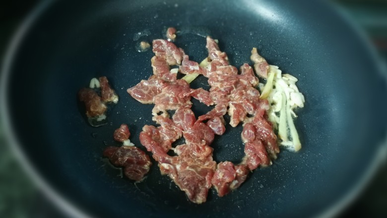 丝瓜烩牛肉,重新起锅,放入油,爆香剩下的蒜末和姜丝,放入腌好的牛肉
