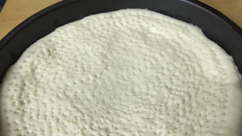 培根虾米披萨,将披萨皮材料以先液体后粉质的顺序,把入面包机,用和面功能搅拌25分钟后,静置1小时。发酵至一倍大后再揉匀、排气,放置披萨盘压成形。