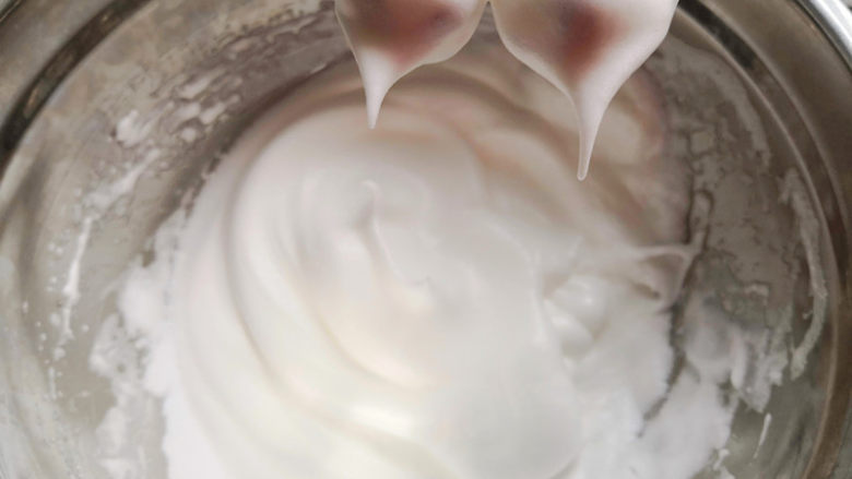 脏脏蛋糕,蛋清冷藏取出,低速打发至鱼眼泡,加入10克糖,高速打发到泡沫开始变得细小,再加10克糖,打发到入分发泡,最后转为低速打发,提起打蛋头,蛋白细腻坚挺,即小弯钩,不需要完全直立的直角,打得过硬蛋白翻拌均匀难度会加大,容易造成翻拌时间过长而出现消泡,反而不容易烤出细腻的蛋糕,