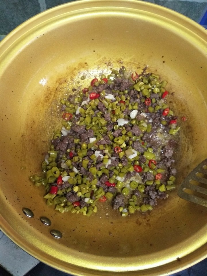 酸豆角炒肉沫,导加入酸豆角,小米辣炒香