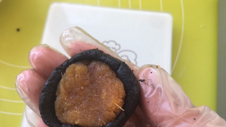 黑凤梨(喜欢你),取17克凤梨馅,放到面皮中间,用虎口一点点推揉面团,包裹上凤梨馅