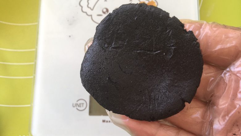 黑凤梨(喜欢你),冰箱取出冷藏的面皮材料,取一块13克面片,用手掌压扁,包裹凤梨酥记得一定要戴一次性手套,免得粘手
