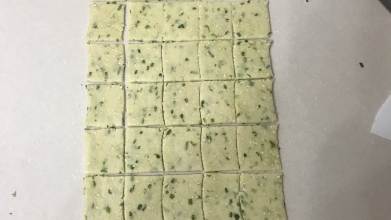 香葱芝麻饼干,边上的先切掉一些,两头同样,切成4厘米宽5厘米长的块。
