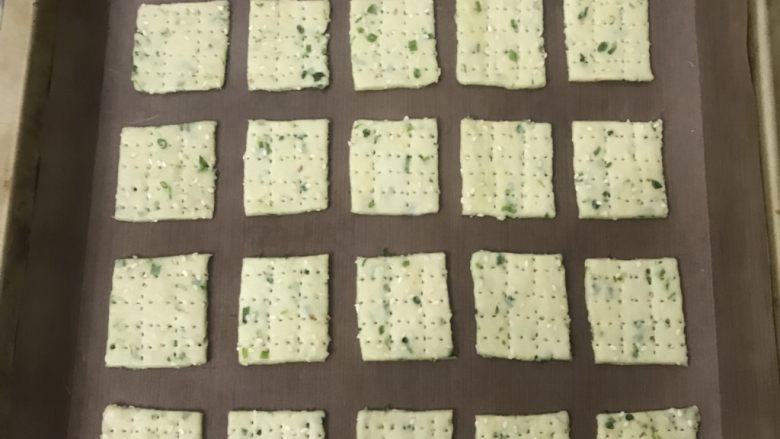 香葱芝麻饼干,整剂摆放在烤盘里,用叉子横竖扎孔,一是为了烤的时候不起泡,再一也为了漂亮,漂亮更加有食欲不是吗?