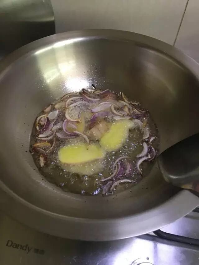 啤酒麻辣小龙虾, 开大火,锅内放食用油,烧到 5 成热,放洋葱进去炸。炸出香味后放生姜进油锅。