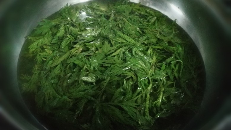 艾叶鸡蛋卷饼,锅里放水,加一勺小苏打,烧开后放入艾草烫一分钟