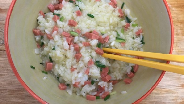 香葱火腿肠鸡蛋米饭煎饼,搅拌均匀，尽量令每粒米饭都裹上鸡蛋液