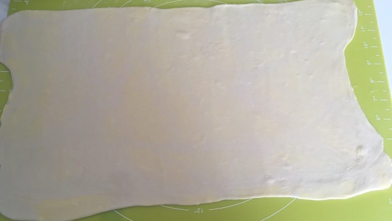 手揉可颂牛角包,取出冷冻的面团,撒点干粉,擀成长方形,厚度约为0.2厘米左右