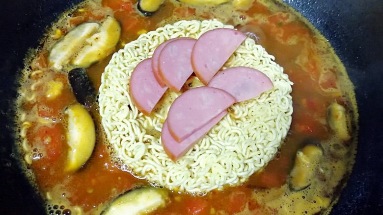 咖喱泡面,下入泡面面饼和火腿肠,烧开以后小火煮2分钟。