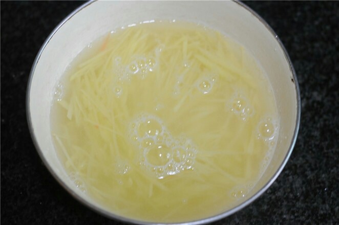 蒸饼卷菜,<a style='color:red;display:inline-block;' href='/shicai/ 23'>土豆</a>丝泡冷水后清洗掉淀粉,捞出,沥干水分