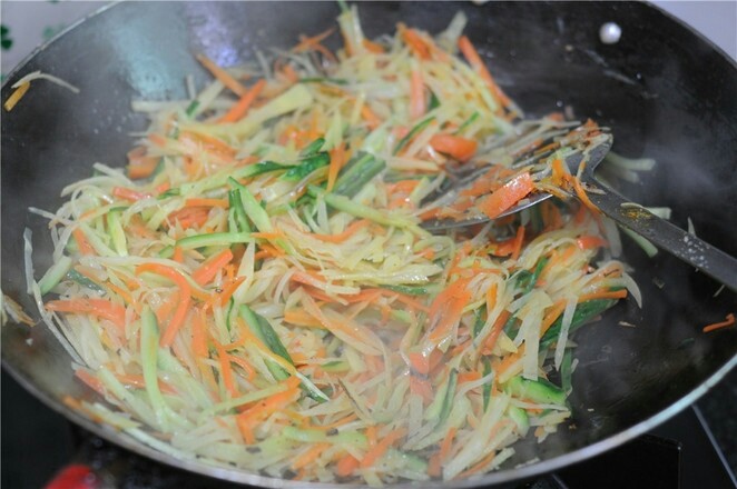 蒸饼卷菜,加入胡萝卜丝和黄瓜丝一起炒熟,加入盐调味即可出锅备用