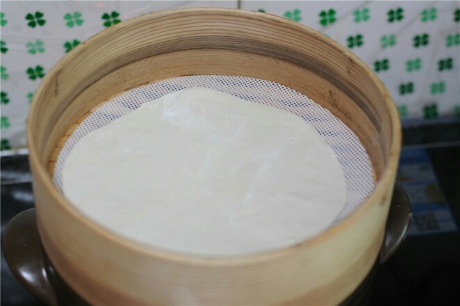 蒸饼卷菜,烧开水,将饼放入蒸笼里盖上锅盖,中火蒸,锅里一边蒸,这边继续擀饼,擀好一张饼,开盖后摞在刚才那张饼上,盖好锅盖继续蒸,如此继续,直到完全蒸完