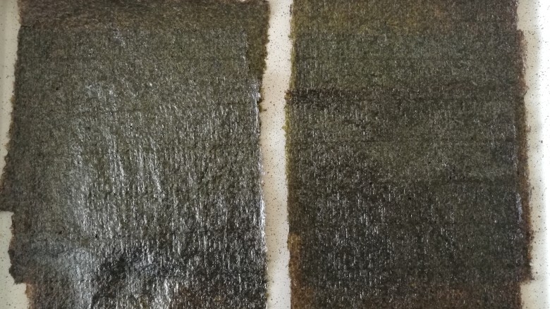 海苔杏仁脆片,把<a style='color:red;display:inline-block;' href='/shicai/ 73872'>海苔片</a>放在烤盘上,烤箱预热150度烤10分钟,一次可以多烤几片,但是不要完全重叠的叠放,完全重叠烤出来的海苔会不平,表面呈现波浪一样的弧度,后期操作很麻烦