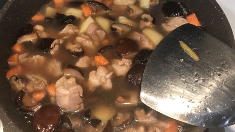 香菇鸡肉焖饭,再倒入香菇水没过所有食材,翻炒均匀