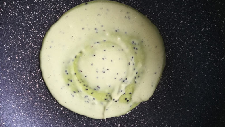 金枪鱼肠鸡蛋卷,锅烧热,小火。舀入一勺面糊,摊平。我用的不粘锅,没有放油。如果用的普通炒锅,可以在锅底刷一层油。